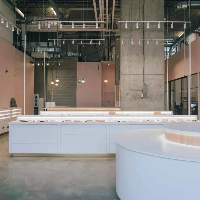 The long white display counter and a round display table in Engage Studio's Toronto showroom
