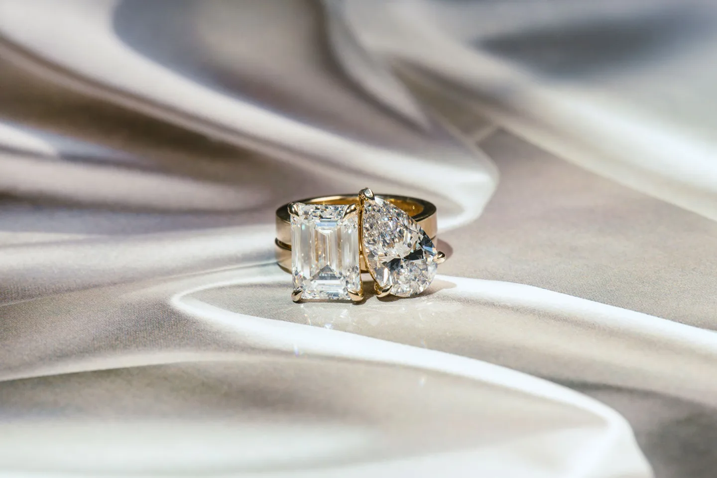 a 2 piece toi et moi engagement ring, made of 1 pear lab diamond band and 1 emerald lab diamond band fitting together like a puzzle.