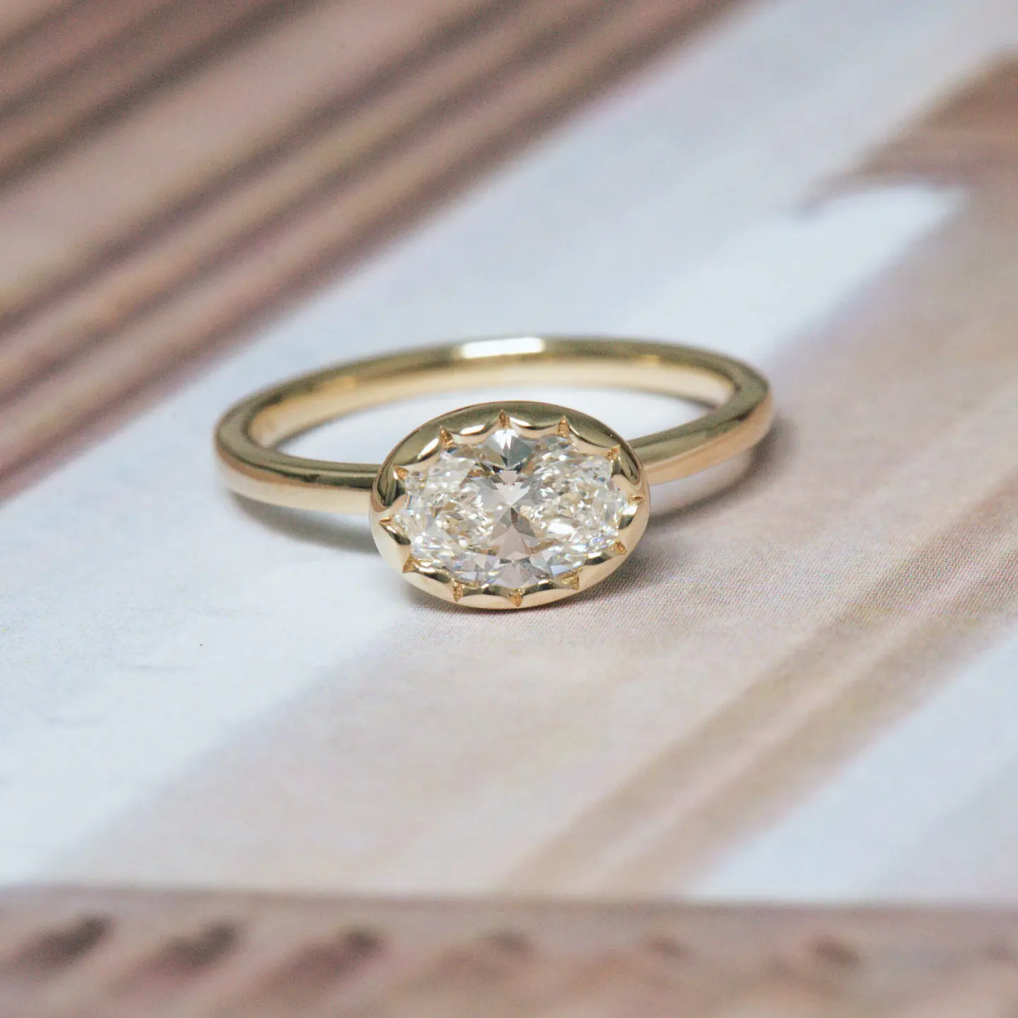 Horizontally Set Oval Engagement Ring Bezel scalloped around oval diamond