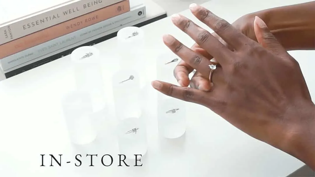 In-store consultation: a hand trying on a yellow gold engagement ring at the studio counter