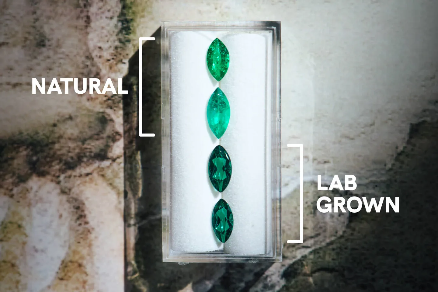 Natural and lab-grown emeralds side by side in a white tray, labelled Natural and Lab Grown