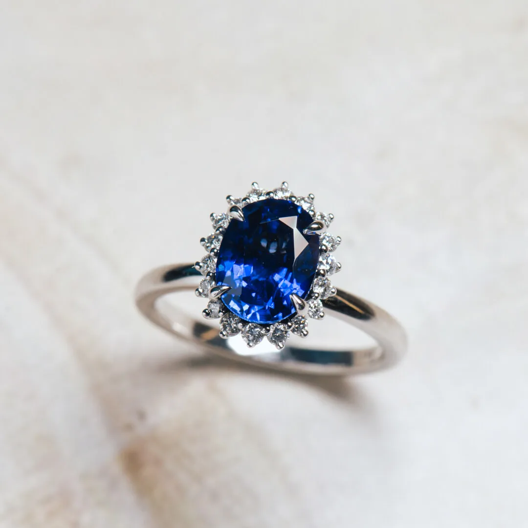Blue sapphire micro halo engagement ring in white gold with an oval centre stone